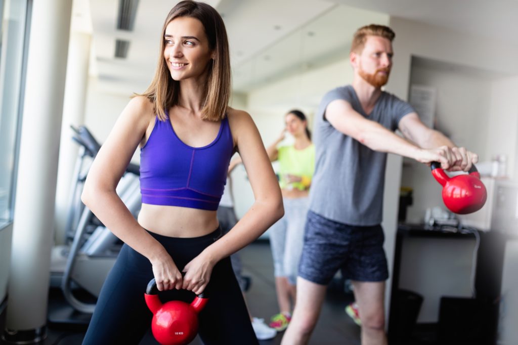 Group having functional fitness training with kettlebell in sport gym