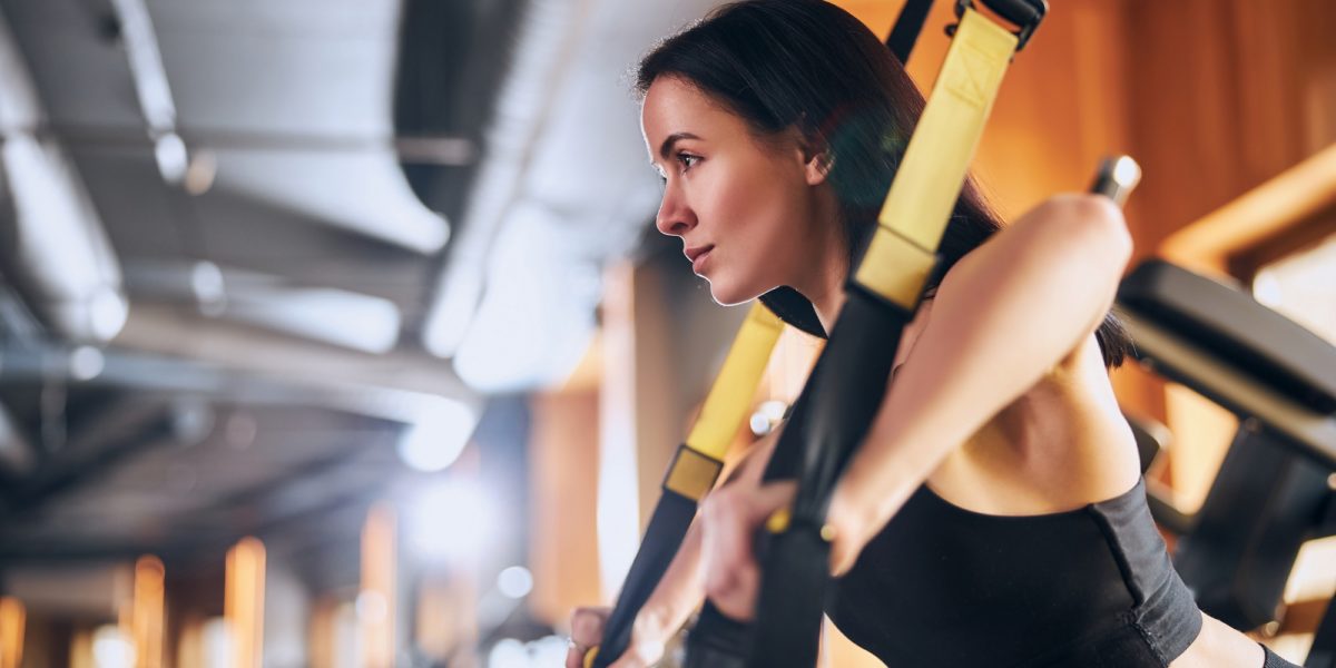 Young woman during strength training in gym